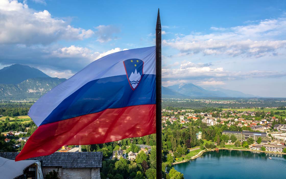 Slowenische Flagge vor landschaftlicher Kulisse