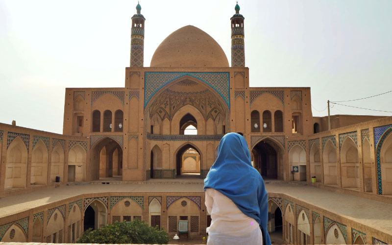 Frau mit Hijab vor einer Moschee